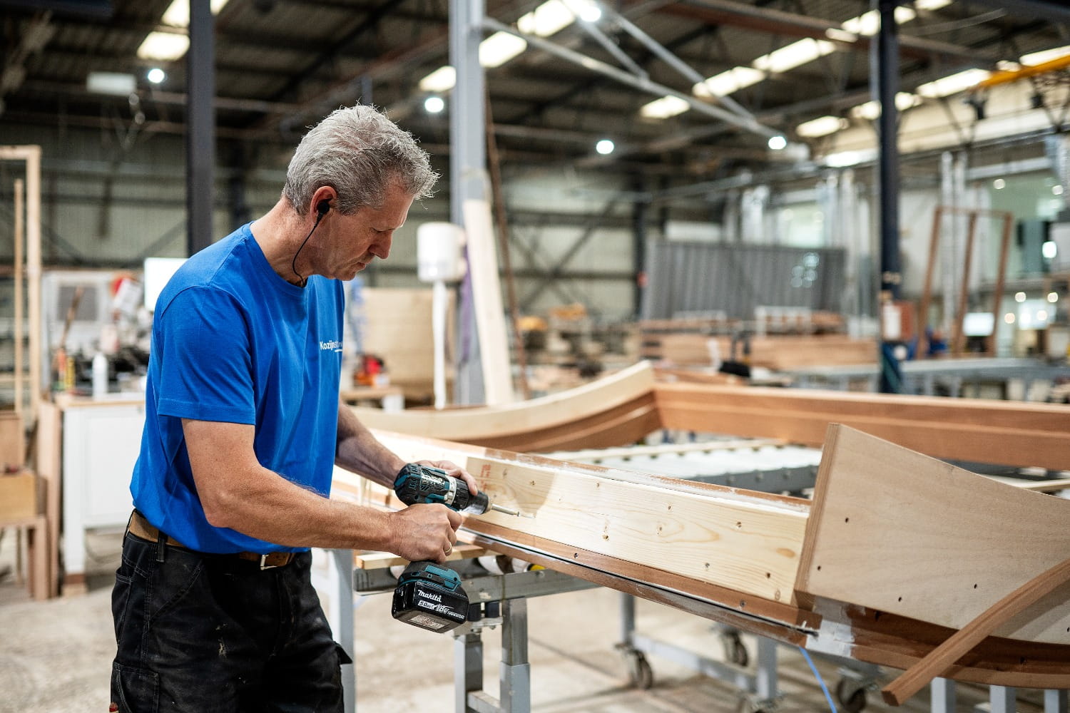 Fabrieksmedewerker in timmerfabriek stelt houten kozijnen samen met vakmanschap